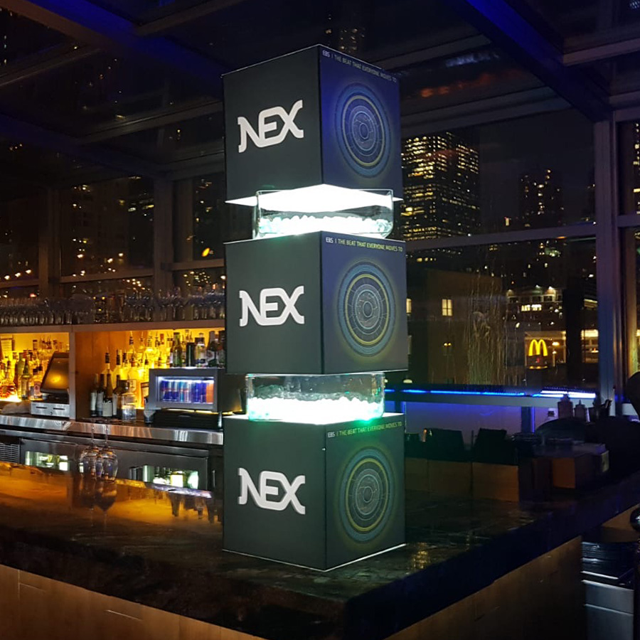 Illuminated EBS Market beats sculpture on the bar of the launch event, three cubes stacked with lights between.